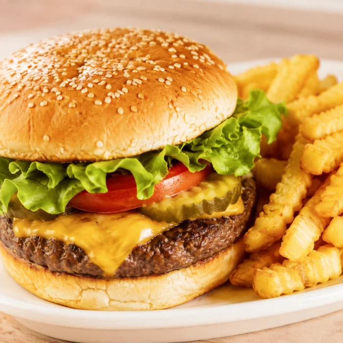 A cheeseburger with lettuce, tomato and crinkle-cut fries.